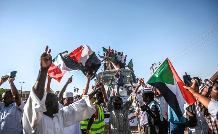 Sudanese protesters from the city of Atbara, sitting atop a train, arrive at the Bahari station in Khartoum