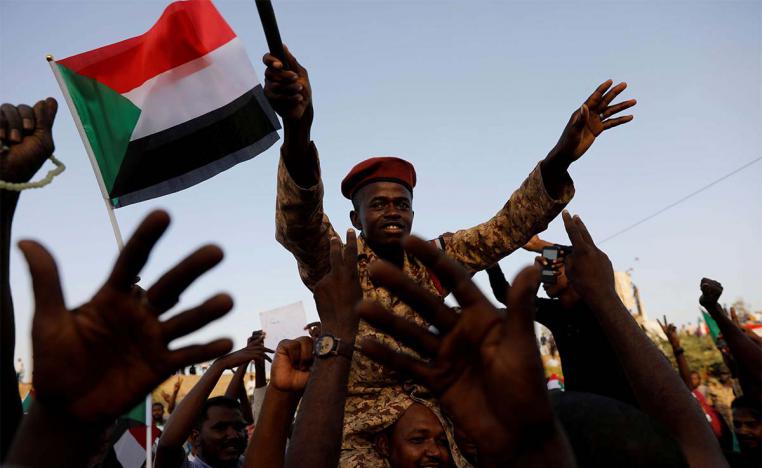 A Sudanese soldier sits on the shoulders of a protester in Khartoum