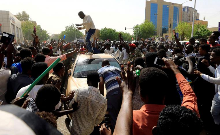 Sudanese demonstrators block the vehicle of a military officer in Khartoum