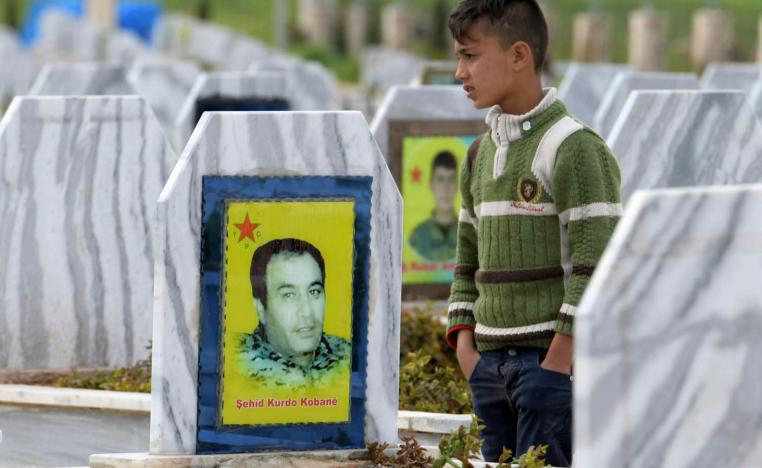 طفل يتجول بين قبور مقاتلين أكراد قضوا في الحرب ضد داعش