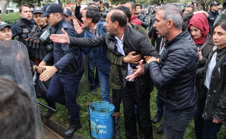 Pro-Kurdish Peoples's Democratic Party (HDP) members discuss with Turkish police during a protest against results of the local elections