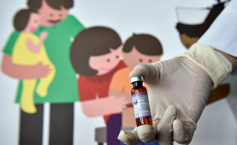 ممرض يحمل لقاح الحصبة في مركز صحي بأندونيسيا