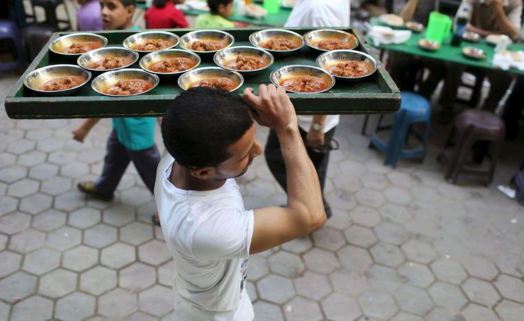 A volunteer carries food to charity tables in Cairo