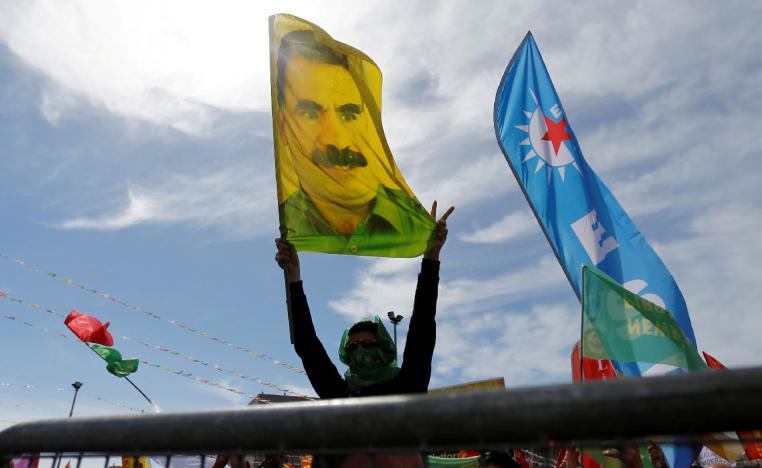 A man holds a flag with a picture of imprisoned Kurdish rebel leader Abdullah Ocalan