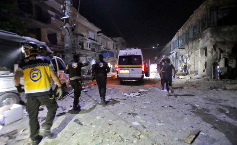 White Helmets rescue volunteers gather at the site of an air strike on a market in the town of Maarat al-Numan