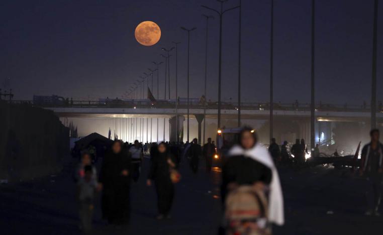 عراقيون يمشون في كربلاء في موسم زيارة الأضرحة