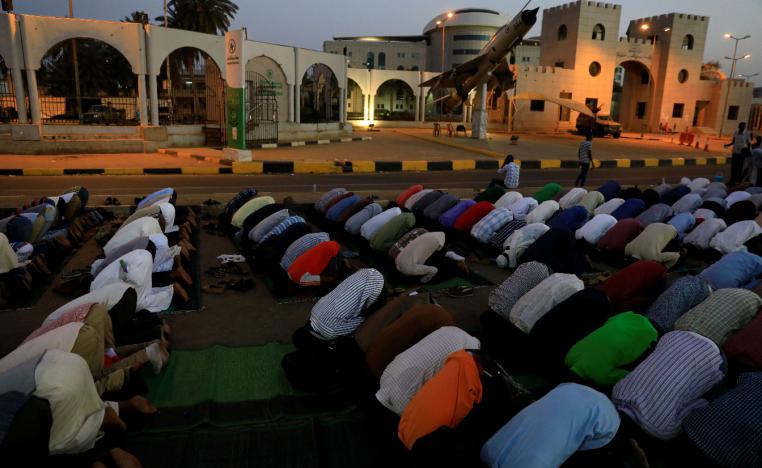 Sudanese protesters pray in front of the defense ministry compound in Khartoum