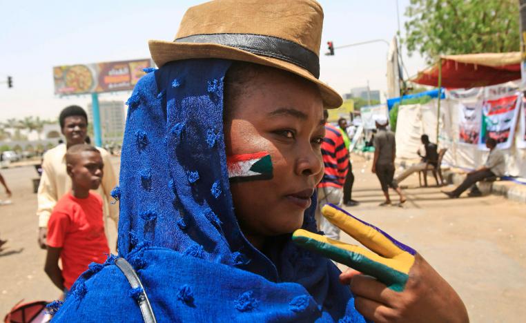 A Sudanese protester with the national flag of Sudan painted on her face
