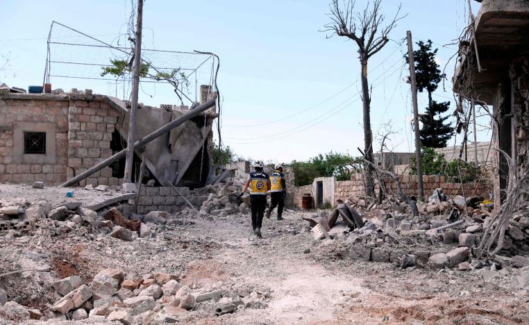 Members of the Syrian Civil Defence, also known as the White Helmets, walk amidst the debris of homes following bombardment by regime forces on the village of Ibdita on May 4, 2019