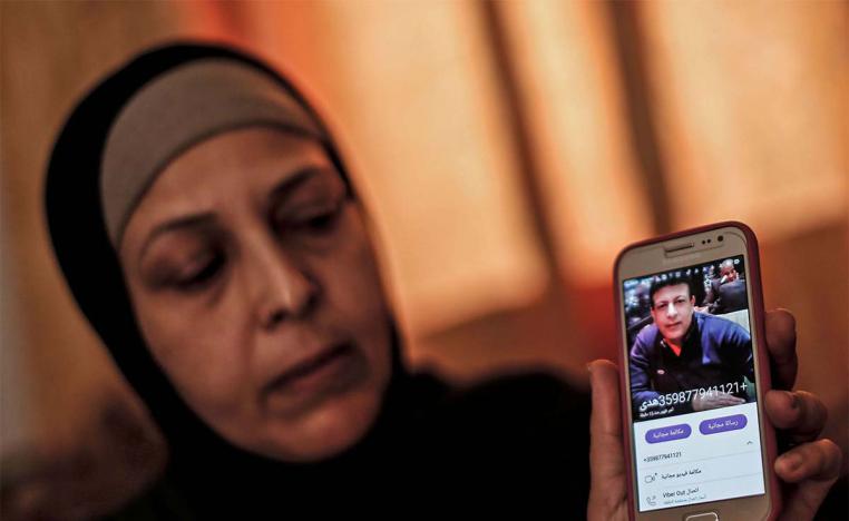 The sister of Zaki Mubarak shows his picture during an interview in their family home in Deir al-Balah