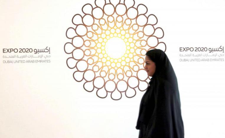 A woman walks past the logo of Expo 2020 in Dubai, United Arab Emirates