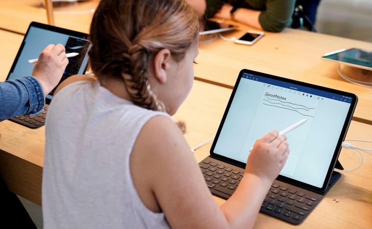 طفلة تستخدم جهاز آيباد من آبل