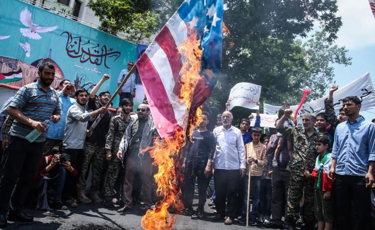 An Iranian man burns the US flag during a protest in Tehran