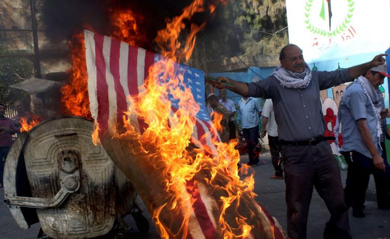 Palestinian refugees in Lebanon's Ain el-Helweh camp burn the US flag during a protest against the Manama conference