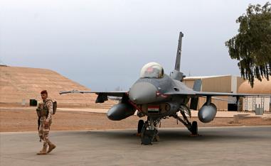 An Iraqi army soldier stand guard near a US-made fighter jet at the Balad Air Base