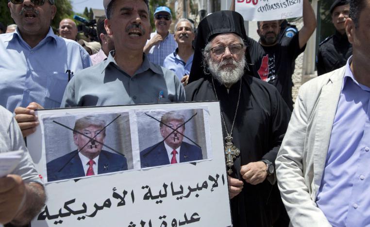 Palestinians protest in Ramallah with sign that reads, 'American imperialism is the people's enemy'.