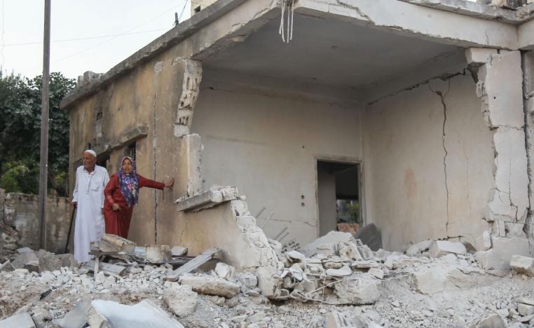 Syrians inspect the damage following reported regime airstrikes on the town of Muhambal
