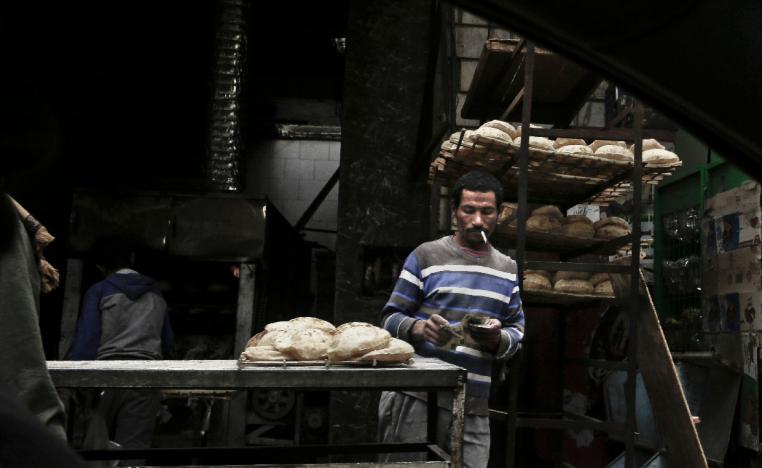 A vendor counts his money at a bread stand in the Sayeda Zeinab neighborhood of Cairo