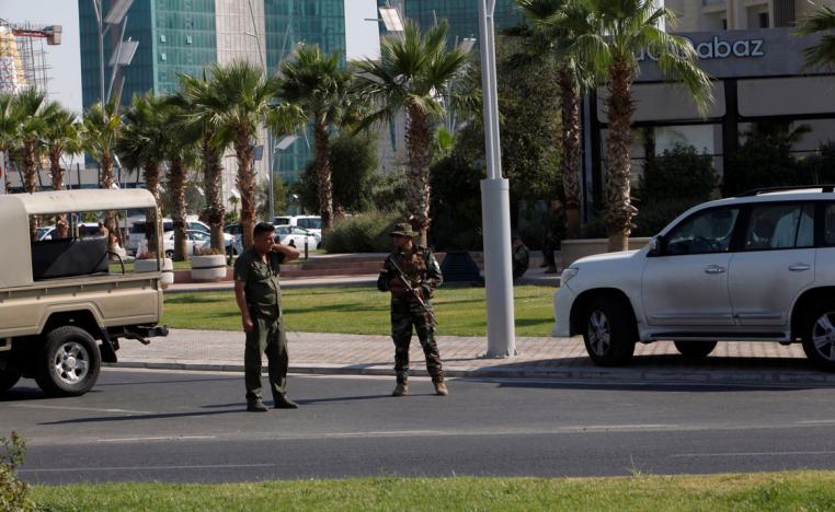Kurdish security members stand guard near a restaurant where Turkish diplomats and Turkish consulate employee were killed in Erbil