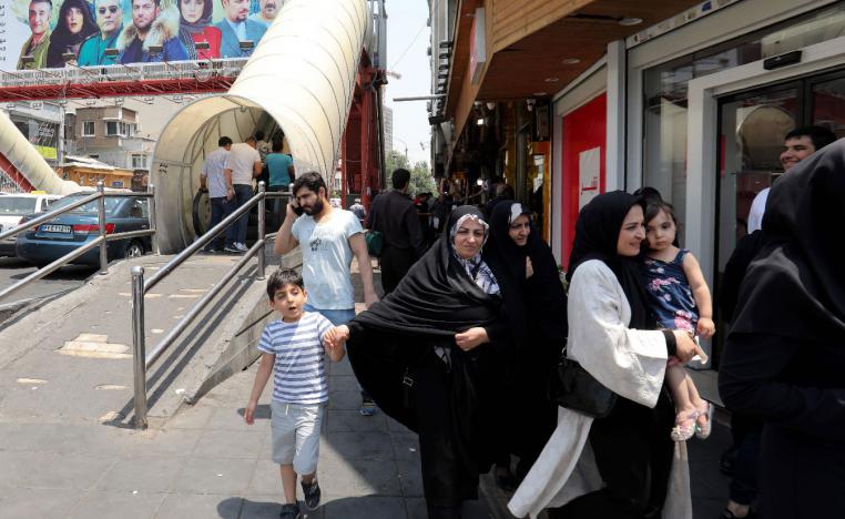 People walk in a busy street in the Iranian capital Tehran