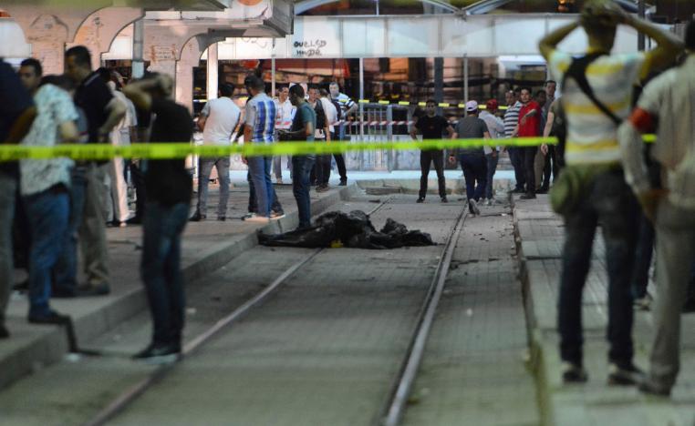 Onlookers gather at the scene outside a metro station where a man blew himself up