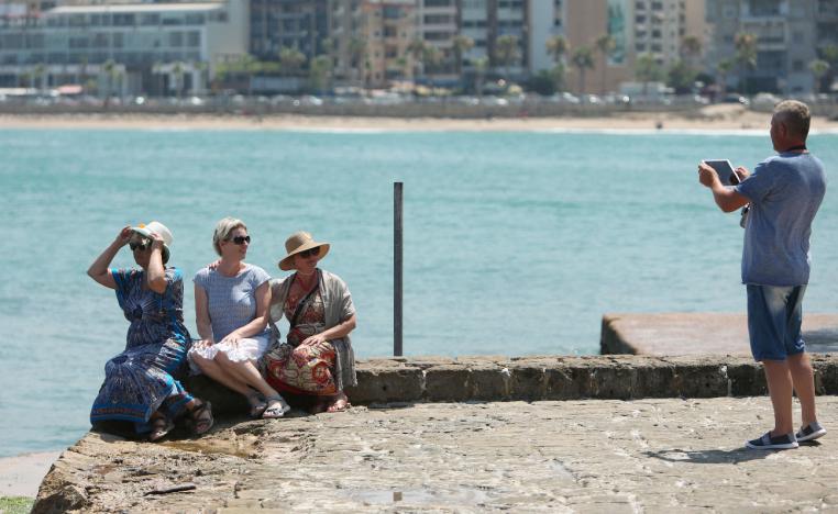 A tourist uses an iPad to take a picture of fellow tourists at the sea castle in the port city of Sidon