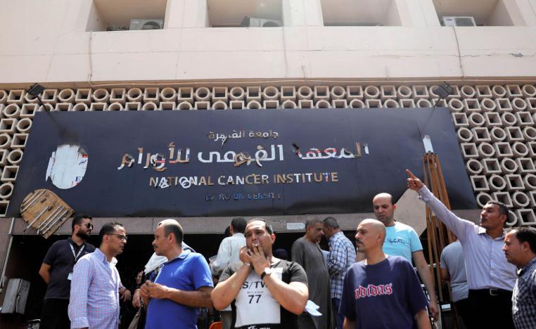 مصريون يقفون أمام معهد الأورام الذي استهدف بهجوم ارهابي