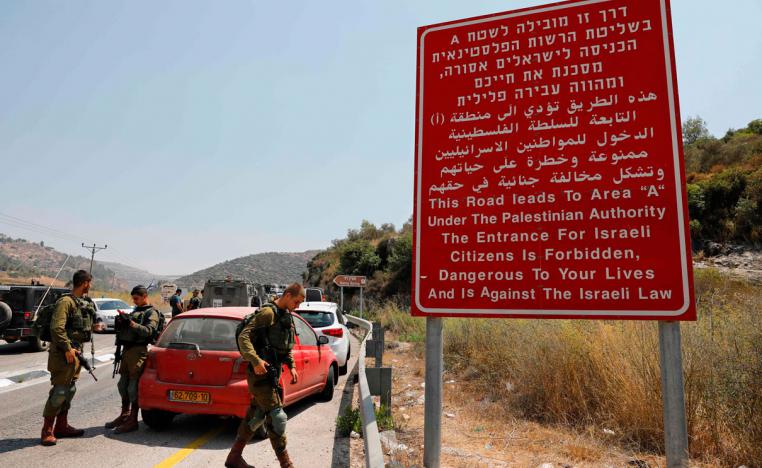 Israeli occupation forces gather at the site where a bomb exploded near the Jewish settlement of Dolev in the occupied West Bank