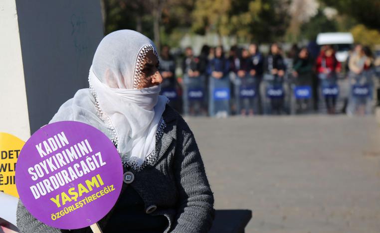 A Turkish demonstrator holds a placard reading "We will stop massacres against women."