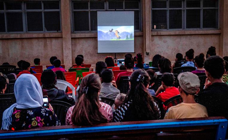 Children attend a film screening as part of the mobile cinema "Komina Film" initiative