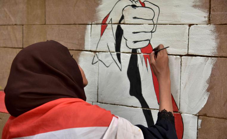 سودانية ترسم غرافيتي على جدار في الخرطوم