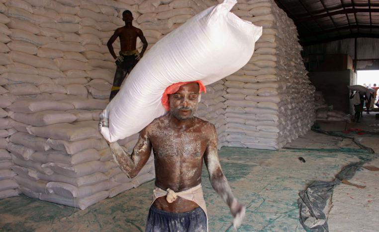 An aid worker carries a sack of flour in the northern Yemeni province of Hajjah