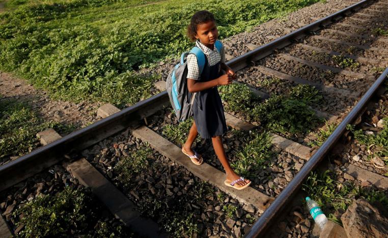 طفلة هندية تعبر سكة القطار خلال ذهابها الى المدرسة