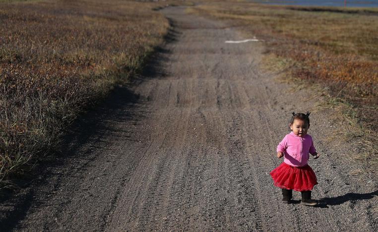 طفلة تمشي في طريق زراعي في ألاسكا حيث المنطقة مهددة بارتفاع منسوب المياه