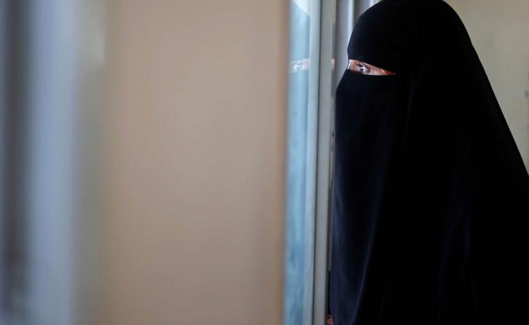 فلسطينية تنظر من الشباك عند معبر رفح في غزة