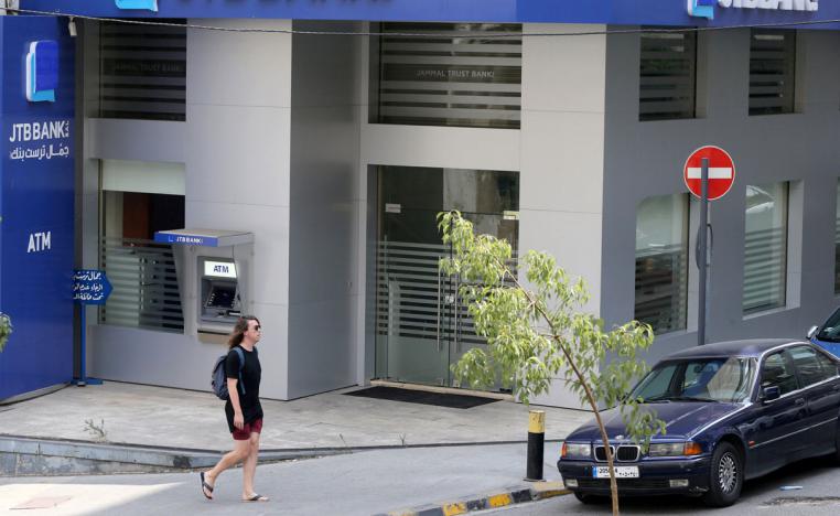 A pedestrian walks past Jammal Trust Bank (JTB) branch in Ashrafieh, Lebanon