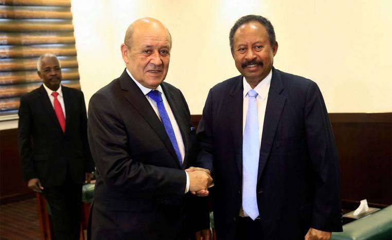 Sudan's PM Abdalla Hamdok shakes hands with French FM Jean-Yves Le Drian during their meeting in Khartoum