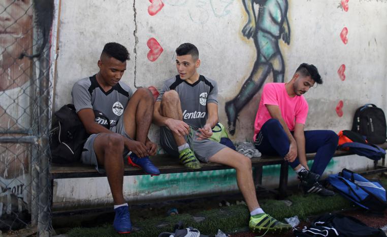 Palestinian players of Gaza soccer club Khadamat Rafah take off their boots after a training session in Rafah