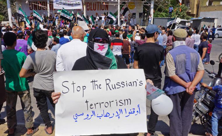 A woman holds up a sign against Russia during a demonstration in Idlib on Sept. 6