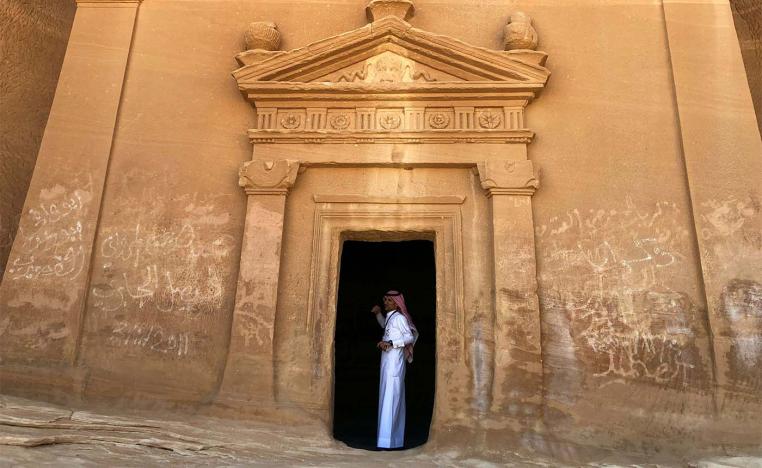 A Saudi tour guide stands inside a tomb at Mada'in Saleh antiquities site