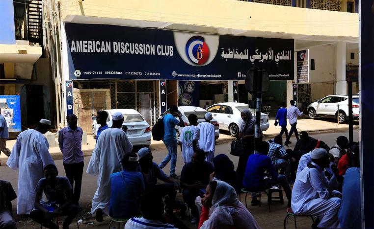People walk past American Discussion club in Khartoum