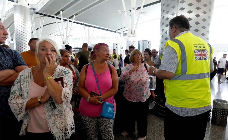 A British government official speaks to tourists, flying with Thomas Cook at Enfidha-Hammamet International Airport