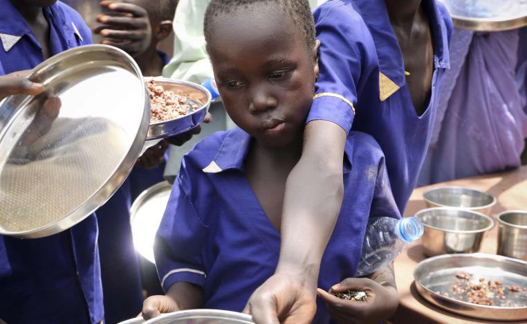 أطفال سودانيون يحصلون على حبوب مطبوخة خلال مبادرة للتغذية أطلقتها اليونيسف