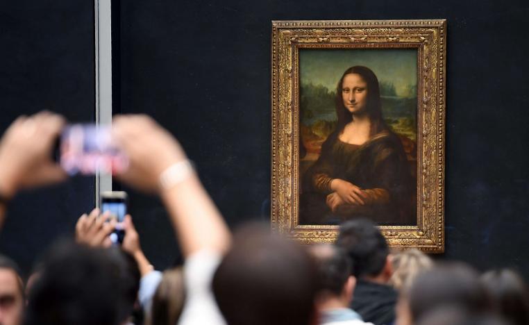 زوار لمتحف اللوفر يلتقطون صورا للوحة الموناليزا