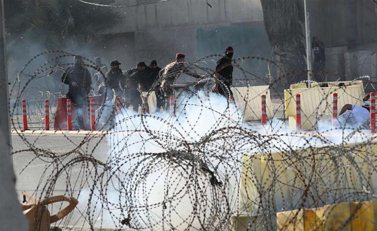 Iraqi security forces fire tear gas to disperse anti-government protesters during a demonstration in central Baghdad,