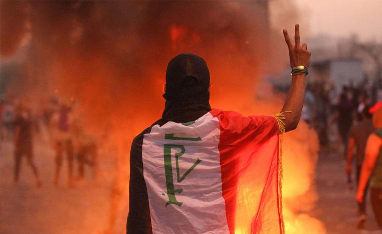An Iraqi protester gestures the v-sign during a demonstration against state corruption, failing public services and unemployment at Tayaran square in Baghdad