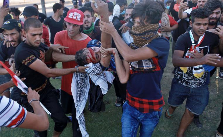 An injured protestor is rushed to the hospital after being shot during a demonstration in Baghdad