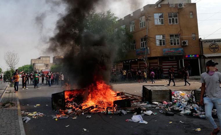 Anti-government protesters set fire and block roads in Baghdad