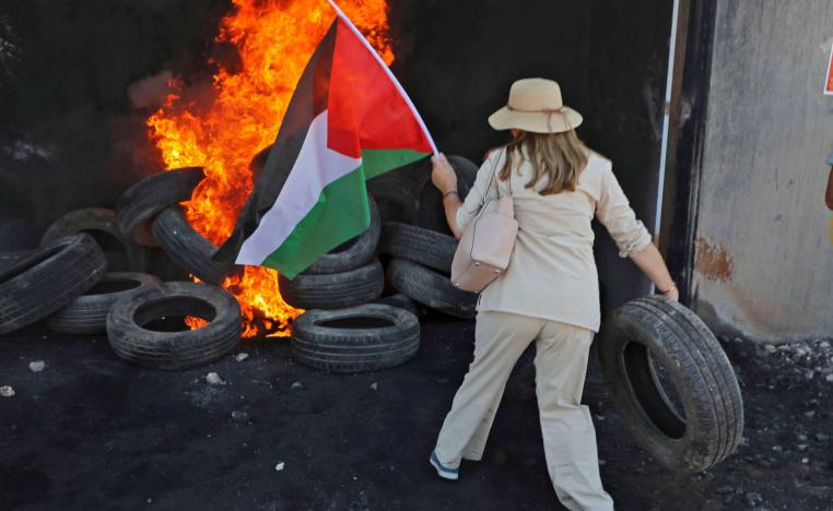 ناشطة غربية ترمي اطارات على كوم يحترق في الضفة الغربية