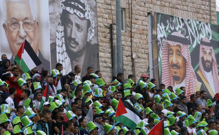 فلسطينيون يحضرون مباراة بين الفريق السعودي والفريق الفلسطيني في الرم في الضفة الغربية